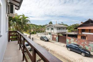 ein Balkon mit zwei auf einer Straße geparkten Autos in der Unterkunft Flat Romântico da Guarda do Embaú SC in Palhoça