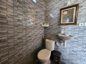 La salle de bains est pourvue de toilettes et d'un lavabo. dans l'établissement Relaxing 2 Bedroom Villa With Private Pool, à Ubud
