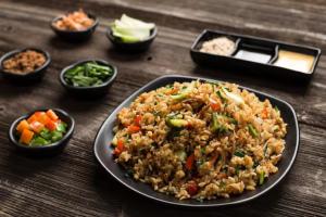 Ratandeep International في نيودلهي: طبق من الطعام مع الرز والخضار على الطاولة