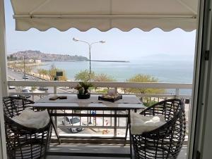 a table and chairs on a balcony with a view of the ocean at SeaNcity Suite in Kavala