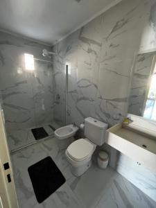 a white bathroom with a toilet and a sink at BE ONE III IRIGOYEN - EXCELENTE DEPARTAMENTO A ESTRENAR MODERNO, UBICADO EN EL CORAZON DEL CAMBA CUA in Corrientes