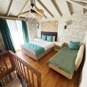 a bedroom with two beds and a fan at Hotel 212 Olympos in Olympos