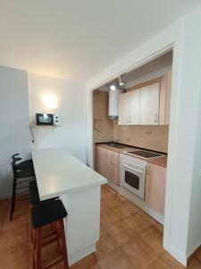 a kitchen with white cabinets and a white counter top at Parque Royal Apartamento in Playa Fañabe