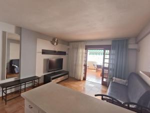 a living room with a couch and a television at Parque Royal Apartamento in Playa Fañabe