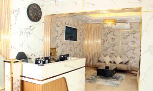 a lobby with a reception desk and a clock on the wall at Al BARAKAH HOTEL in Sharjah