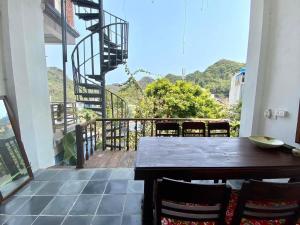 uma varanda com uma mesa e cadeiras e uma escada em espiral em Chez Phuong Cat Ba -Private entire house em Ilha de Cát Bà