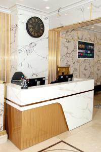 a reception counter with a clock on a wall at Al BARAKAH HOTEL in Sharjah