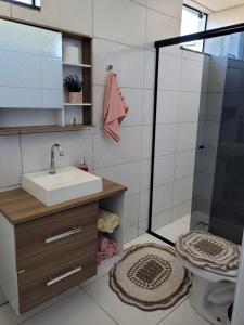 a bathroom with a sink and a shower at Pousada Aparecida in Ametista do Sul
