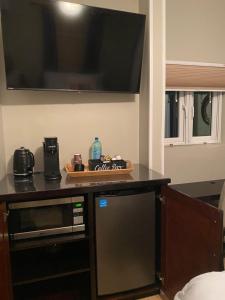een keuken met een magnetron en een tv aan de muur bij Island Breeze Guest Suite in Nassau