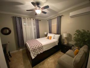 een slaapkamer met een bed en een plafondventilator bij Island Breeze Guest Suite in Nassau