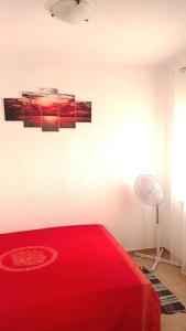 a bedroom with a red bed and a lamp at Apartments Happy Day in Karlobag