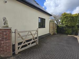 una casa blanca con una puerta y una valla en Ole Butt Cottage en Cinderford