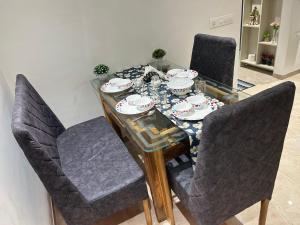 a dining room table and chairs with a table and plates on it at 1BHK In Hiranandani Powai (D) in Mumbai