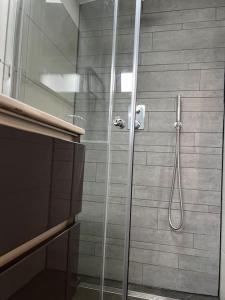 La salle de bains est pourvue d'une douche avec une porte en verre. dans l'établissement De Egelburcht, à Garderen