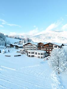 a resort with snow on the ground and buildings at Hotel Das Urbisgut in Altenmarkt im Pongau