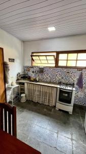 cocina con fregadero y fogones horno superior en Casa de temporada na Serra Macaense, en Macaé