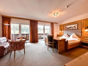 a hotel room with a bed and a desk at Hotel Das Urbisgut in Altenmarkt im Pongau +218 photos
