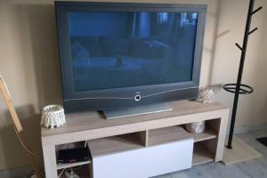 TV de pantalla plana con soporte de madera en Grand Appartement Cosy Chez Pépette à 5 min de Colmar en Houssen