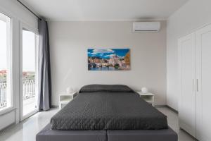 a bedroom with a bed and a large window at Travelershome Ciampino Airport GuestHouse in Ciampino