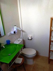 a bathroom with a green sink and a toilet at casa Emilia Cotillo Mar in Cotillo