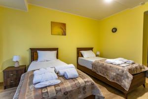 Duas camas num quarto com paredes amarelas em LILEO Hotel em Kutaisi