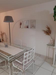 a dining room with a glass table and a chair at Résidence Les Pêcheries in Saint-Vaast-la-Hougue