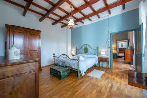 sypialnia z łóżkiem i komodą w pokoju w obiekcie Charming Villa I Tre Archi - Happy Rentals w mieście Pisano