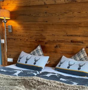 ein Bett mit zwei Kissen und einer Holzwand in der Unterkunft Ferienwohnung-Königsschlösser in Füssen