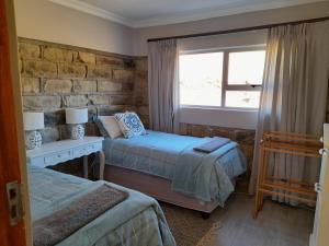 a bedroom with two beds and a window at Zamenkomst River Lodge in Maclear