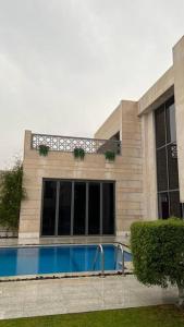 um edifício com uma piscina em frente em شاليه فيلا غرفتين نوم em ‘Anqāʼ