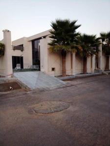 um edifício com uma palmeira em frente em شاليه فيلا غرفتين نوم em ‘Anqāʼ