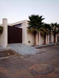 um edifício com palmeiras em frente em شاليه فيلا غرفتين نوم em ‘Anqāʼ