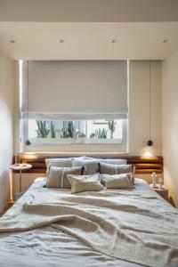 um quarto com uma cama grande e uma janela em Designer Gem in the Old North by FeelHome em Tel Aviv