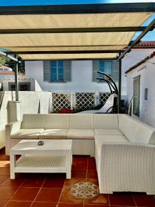 a patio with couches and a table on a roof at in Hydra in Hydra