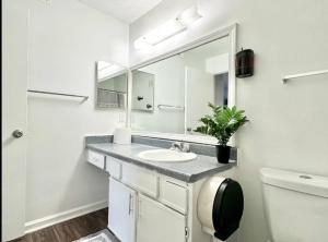 Baño blanco con lavabo y espejo en King Suite - Private Bath - Home Theater Room 1, en Morrow