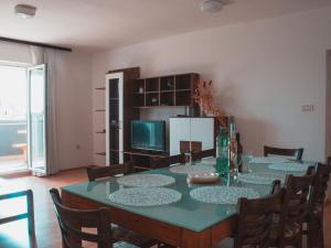 a dining room with a table with chairs and a refrigerator at Apartments Ankica in Štinjan