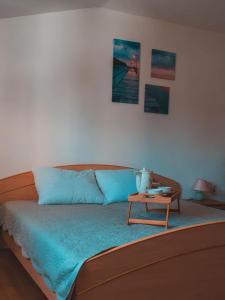 a bedroom with a bed with blue sheets and a table at Apartments Ankica in Štinjan