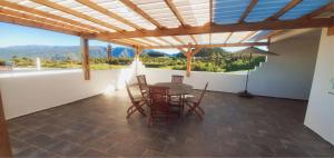 a patio with a table and chairs and a view at Le Margaret Holidays in La Plaine des Cafres