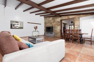 een woonkamer met een witte bank en een tafel bij Villa Selena in Pájara