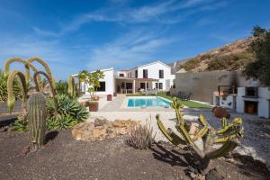 a house with a swimming pool and cactus at Villa Selena in Pájara