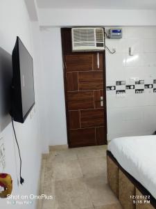 a small room with a television and a bed at Raj Residency Chhatarpur in New Delhi +21 photos
