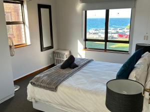 a bedroom with a large bed with a view of the ocean at Beacon Point in Mossel Bay