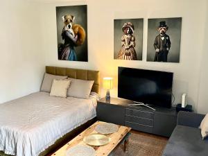 a bedroom with a bed and a flat screen tv at Apartament Kameralny nad Motławą in Gdańsk