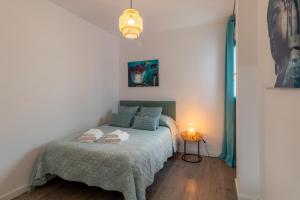 a bedroom with a bed with a blanket and a lamp at RentitSpain - Playa Granada - Apartamento Aguacate Golf y Costa in Motril +30 photos