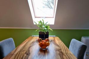 eine Schale Obst auf einem Holztisch mit einem Fenster in der Unterkunft Apartament Nawojowski in Nowy Sącz