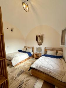 a bedroom with two beds and a chandelier at 2-single beds beit zeina horse riding in Cairo