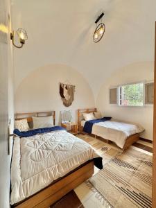 开罗2-single beds beit zeina horse riding的有两张床和一扇窗户的卧室