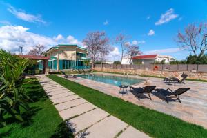 - une piscine dans une cour avec des chaises et une maison dans l'établissement Serenity Villas, à Kolimbia