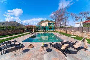 una piscina con sedie e una casa di Serenity Villas a Kolímbia