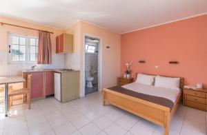 a large bedroom with a bed and a kitchen at Socrates studio in Laganas